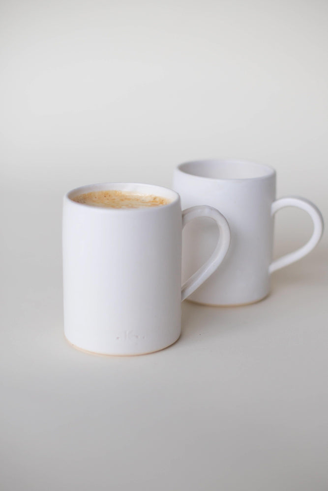 A handthrown ceramic mug in our Kinship Collection off-white glaze.