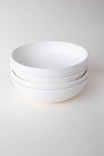 A handthrown ceramic pasta bowl in our Kinship Collection off-white glaze.