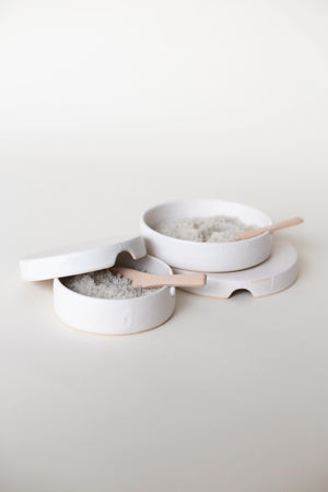 A handthrown ceramic salt cellar with wooden spoon in our signature off-white glaze.