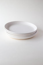 A handthrown ceramic lunch plate in our Kinship Collection off-white glaze.
