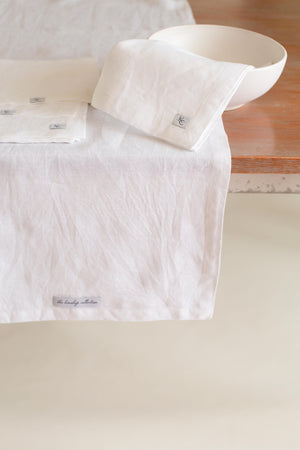 A 100% linen table runner in neutral tones.