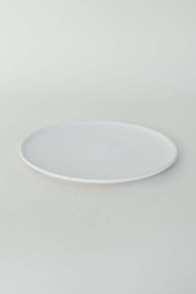 A handthrown ceramic side plate in our Kinship Collection off-white glaze.